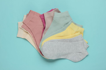 Set of pastel color socks on blue background. Top view