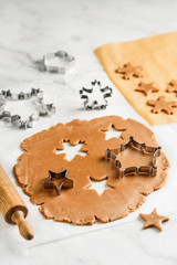 Cooking christmas gingerbread cookies with stars and snowflakes on a marble background. Selective focus