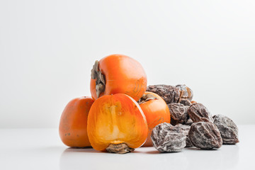 dried persimmon hanging on rope on white background