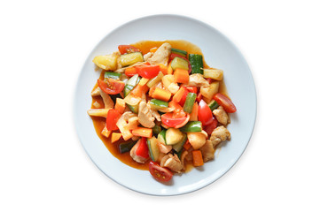 sweet and sour fried Thai dish in white plate isolated on white background. Healthy sweet and sour fried vegetable, tomato, bell pepper, cucumber, pineapple and chicken top view