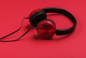 Stylish wired red headphones on red background. Music lover concept.