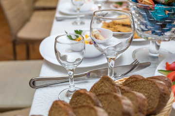 banquet table served with instruments and decorated with empty wine glasses