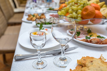 banquet table served with instruments and decorated with empty wine glasses