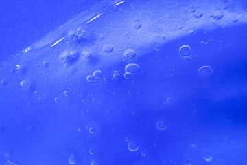 Cosmetic gel close-up. Macro photo. The concept of cosmetic products, skin and hair care, beauty and health. Background image in trendy blue.