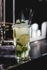 glass of cold mojito on a table in the bar. bright light