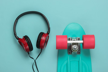 Cruiser board, headphones on blue background. Summer fun. Retro style. 80s. Top view