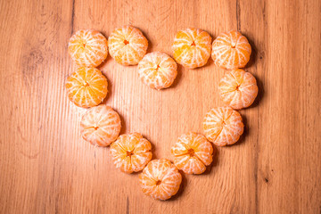 Slices of tangerine in the shape of hearts on white background
