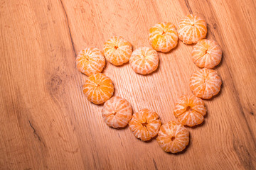 Slices of tangerine in the shape of hearts on white background