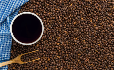 Top view of a Cup of coffee, cappuccino on a table with coffee beans with a wooden spoon