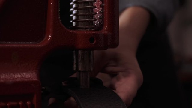 Close up craftswoman working with leather belt. Shoe production process in factory. Close up leather craftsman working with natural leather using hammer. Handmade concept, Working process with leather