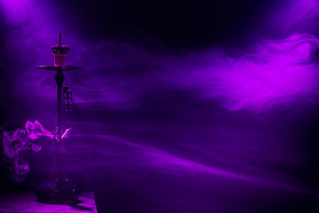 The classic hookah. Beautiful background, with colored rays of light and smoke. The concept of hookah Smoking.