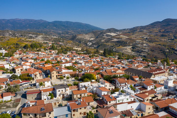 Fototapeta na wymiar Aerial view of Omodos⁩, ⁨Limassol⁩, ⁨Cyprus⁩. Beautiful houses with red roofs. Mountains in the background