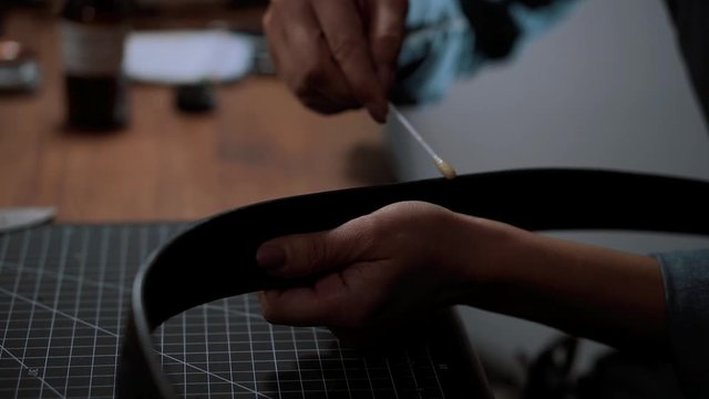 Close up craftswoman working with leather belt. Shoe production process in factory. Close up leather craftsman working with natural leather using hammer. Handmade concept, Working process with leather