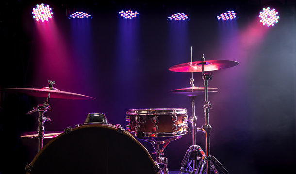 Drums and drum set. Beautiful blue and red background, with rays of light. Beautiful special effects of smoke and lighting. Musical instrument. Close-up photo.