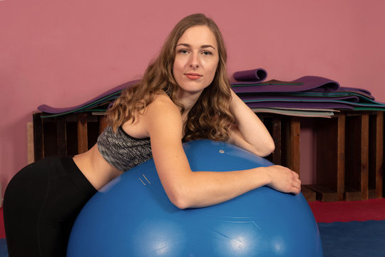 Woman on a fitness ball in a gym - Image
