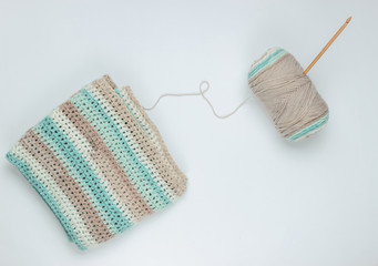 Yarn with skeins of woolen threads and wooden crochet for knitting on white background. Top view