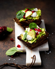 Toast with avocado, soft cheese and pomegranate