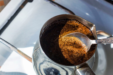 Barista preparing hot tasty drink from copper turk, boils water for coffee on small fire in cezve. Coffee turk made of organic copper, cezve to kitchen. Copper turk for real gourmet coffee at cezve