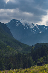 Fototapeta premium Mountain range under cloudy sky. Snowy peaks of mountains rocks