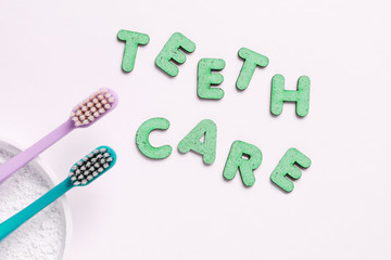 Two toothbrushes, tooth powder on white background with slogan teeth care. Minimalism oral hygiene...