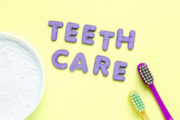 Two toothbrushes, tooth powder on green background with slogan teeth care. Minimalism oral hygiene...