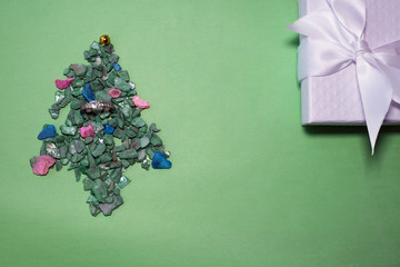 celebration, winter holidays and advertisement concept - christmas tree with gifts and santa hat over concrete wall background