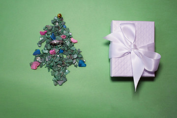 celebration, winter holidays and advertisement concept - christmas tree with gifts and santa hat over concrete wall background