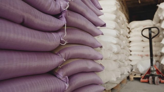 Bags with flour in warehouse of flour factory. Flour stock. Mill warehouse