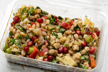 Instant Take Away Healthy Salad with Wheat, Lentil, Pomegranate Seeds, Pickles and Pear Slices in Plastic Box / Package Container.