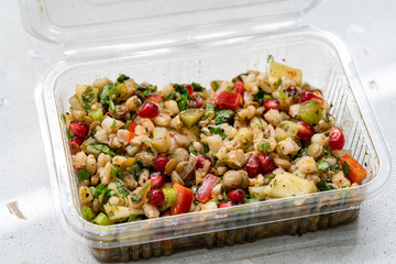 Instant Take Away Healthy Salad with Wheat, Lentil, Pomegranate Seeds, Pickles and Pear Slices in Plastic Box / Package Container.