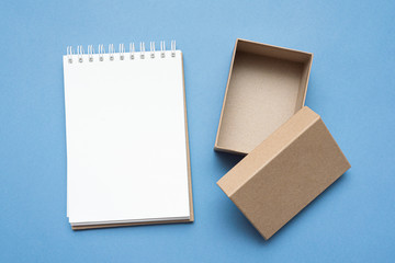Brown cardboard box and blank on blue background.