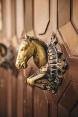 An old doorknob in the shape of a horse's head.