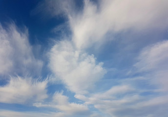 Fototapeta premium White clouds against a clear blue sky.