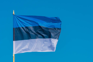 The flag of Estonia flying in breeze wind on sky background