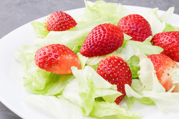 Healthy summer diet salad with strawberries and leaves iceberg lettuce. Light snack, healthy food. Copy cpace