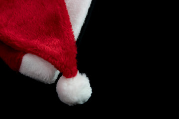 Obraz na płótnie Canvas Selective focus of Santa hat on the black background as the Christmas concept (minimal style).