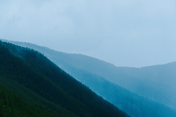 Fototapeta premium mountain valley under cloudy sky, rock ridge on horizon, hiking in mountains, rest and meditation in nature