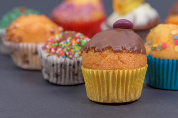 assorted fresh tasty muffins on dark background