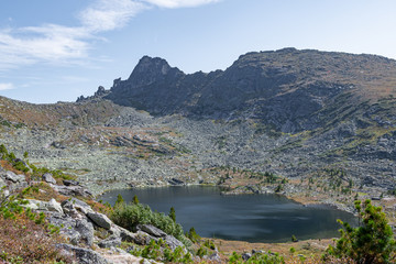 Obraz premium lake under rock ridge, autumn hiking in mountain valley