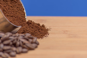 Coffee beans and ground powder on a wooden background. Top view with copy space