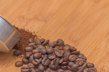 Coffee beans and ground powder on a wooden background. Top view with copy space