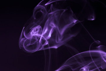 Mystic smoke patterns moving in colour on black background.