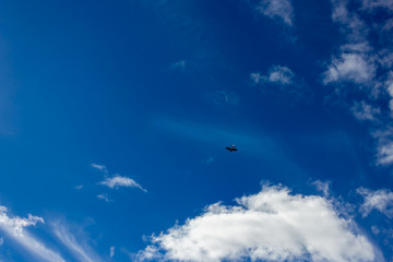 small plane far in the blue sky designer background