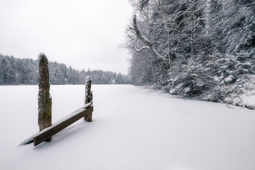 White snowy landscape with wooden fence at mood winter day in Finland