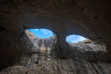 Panoramic view of Prohodna cave also known as God's eyes near Karlukovo village, Bulgaria. Colorful cave formation with giant entrance. Panorama