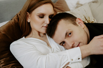 Obraz na płótnie Canvas Business couple on bed in hotel room - tender hugs