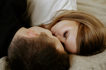 Close-up portrait of a young couple in bed at home - top view