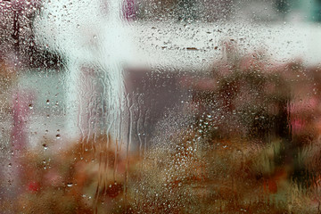 Wet window glass with drops and abstract blurs