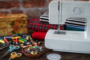Many colorful threads and a sewing machine on the table