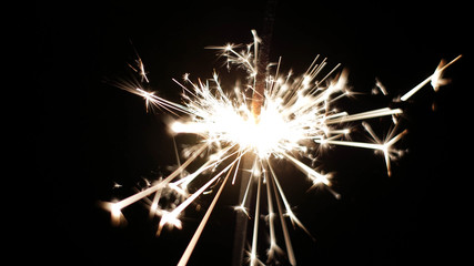 Fototapeta premium Close-up of firework sparkler burning. Fireworks burn on a black background